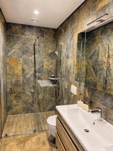 a bathroom with a shower and a toilet and a sink at Kregždžių apartamentai in Šventoji +4 photos
