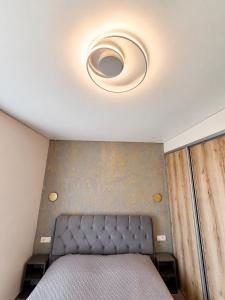 a bedroom with a ceiling with a bed in it at Kregždžių apartamentai in Šventoji