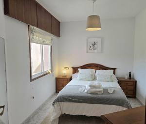 a bedroom with a bed with two towels on it at Mar de Laxe Vistas al mar y Costa da Morte in Cabana de Bergantiños