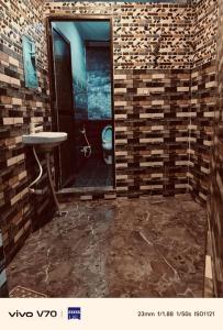 a bathroom with a sink and a toilet in a room at Thakur JI Residency in Varanasi