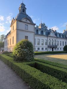a large white building with a clock tower at Kronovall Park Residence in Skåne-Tranås