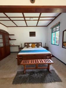 a bedroom with a bed and a bench in it at Lobo's Retreat in Kurunegala