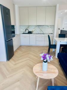 a kitchen with a table with a vase of flowers on it at Apartament Drohiczyńska in Siemiatycze