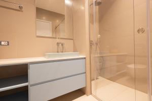 a bathroom with a sink and a shower at Aria apartment 2 in Dhërmi +14 photos