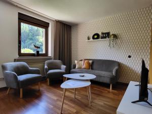 a living room with a couch and two chairs and a table at Ferienwohnung Tutbach in Jünkerath +1 photo
