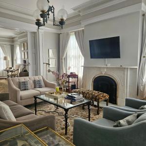 a living room with a fireplace and a tv at Peach Grove House in Warwick