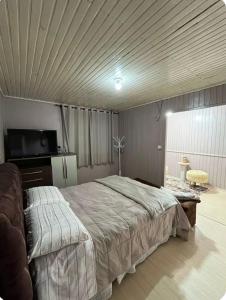 a bedroom with a large bed and a tv at Incantare in São Joaquim