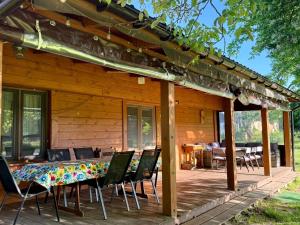 a wooden cabin with a table and chairs on a deck at Poleskie zacisze, domek Bocian, kominek, balia,sauna,wifi in Helenin