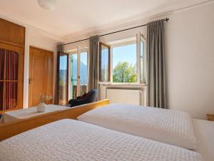 a hotel room with two beds and a window at Pension Villa Bergkristall in Eschenlohe