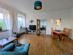 a living room with a table and chairs and a television at Olsinky in Ústí nad Labem