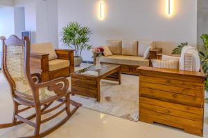 a living room with wooden furniture and a couch at Hotel Beach Castle in Arugam Bay