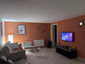 a living room with a couch and a flat screen tv at Le cosy d'Aramon in Aramon