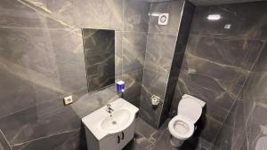a bathroom with a toilet and a sink and a mirror at Grand Black Hotel in Mersin +13 photos
