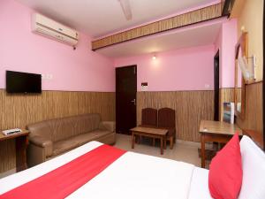 a bedroom with a bed and a couch and a television at Hotel O Centre Point in Rānchī