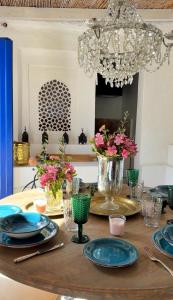a dining room table with blue plates and flowers on it at Dar Almaz in Mijas