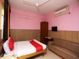 a bedroom with a bed and a couch at Hotel O Centre Point in Rānchī +30 photos