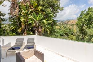 a balcony with two chairs and a view of trees at Dar Almaz in Mijas