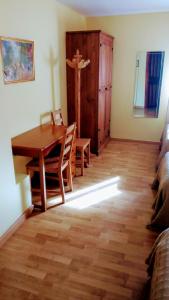 a living room with a wooden table and a wooden floor at El Pozo de la Cotarra in Cabezuela