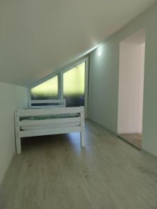 a white room with a bench and two windows at Apartmani Lohovo 2 in Lohovo +2 photos