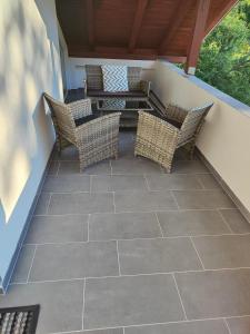 a patio with wicker chairs and a table at Apartmani Lohovo 2 in Lohovo