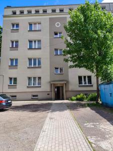 a large building with a tree in front of it at Apartament Krótka in Łomża