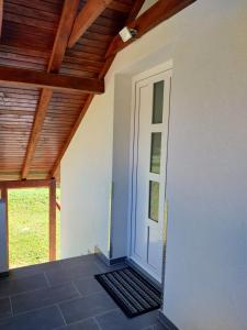 a room with a white door and a wooden ceiling at Apartmani Lohovo 2 in Lohovo