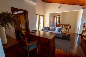 a living room with a desk and a couch at Villa Fernandos in Praia de Mira