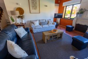 a living room with a leather couch and a fireplace at Villa Fernandos in Praia de Mira