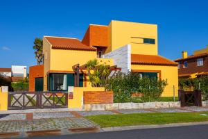 a yellow house with an orange roof at Villa Fernandos in Praia de Mira