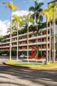 a red sculpture in front of a building with palm trees at Selva Vista in Pereira