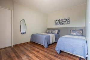 a bedroom with two beds and a mirror on the wall at APT 302 - 5 min do aeroporto com ar-condicionado, rodoviária e embaixadas in Brasília