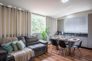 a living room with a couch and a table with chairs at APT 302 - 5 min do aeroporto com ar-condicionado, rodoviária e embaixadas in Brasília