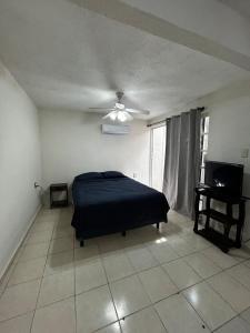 a bedroom with a bed and a ceiling fan at Comfortable house with an excellent location in Veracruz