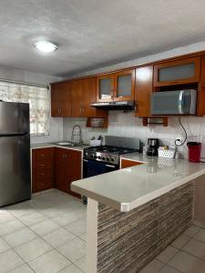 a kitchen with wooden cabinets and a stainless steel refrigerator at Comfortable house with an excellent location in Veracruz