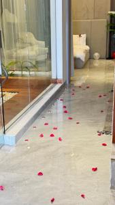 a bunch of red rose petals on the floor of a room at شالية رواء كبلز in á¸¨arÄdÄ« +28 photos