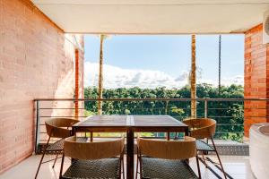 a balcony with a table and chairs and a large window at Selva Vista in Pereira