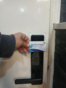 a person holding a welcome sign in a refrigerator at Hotel Weston in Rockford
