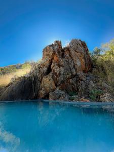 a large rock next to a body of water at Glocke Mountain Camp in Outjo