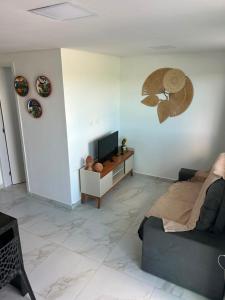 a living room with a couch and a television at Flat no Alto de Bezerros Casa 7 in Bezerros