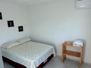 a small bedroom with a bed and a table at Flat no Alto de Bezerros Casa 7 in Bezerros +20 photos