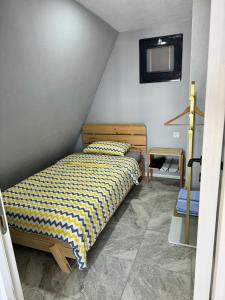 a bedroom with a bed with a yellow and black comforter at Banderabungalov in Kartepe