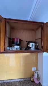 a kitchen with two pots and pans on a shelf at House in Djerba s1 in Midoun +20 photos