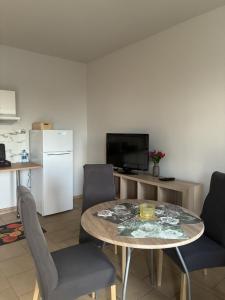 ein Wohnzimmer mit Tisch, Stühlen und Kühlschrank in der Unterkunft Łowicka22 in Piątek
