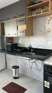 a kitchen with a sink with a bottle of wine at Flat no Alto de Bezerros Casa 7 in Bezerros