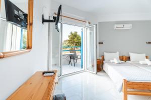a bedroom with a bed and a sliding glass door at Fiore Di Mare Studios in Lassi