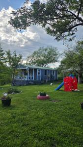 a yard with a house and a playground at Căsuța din poveste in Sohodol
