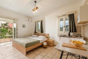 a bedroom with a bed and a kitchen with a sink at Amorosa Nest - Adults Only by Eutopia in Syvota