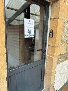 a garage door with a sign in the window at Les gîtes du Chemin Le Compostelle in Paray-le-Monial