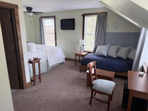 a bedroom with a bed and a couch and a chair at The Old Lantern Inn in Charlotte
