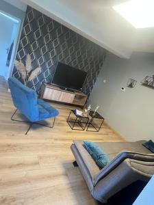 a living room with a couch and a tv at Charmant appartement Cosy porte de Colmar in Sainte-Croix-en-Plaine